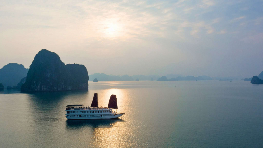A Lovely Boat Sailing Under The Scenery Of Halong Bay