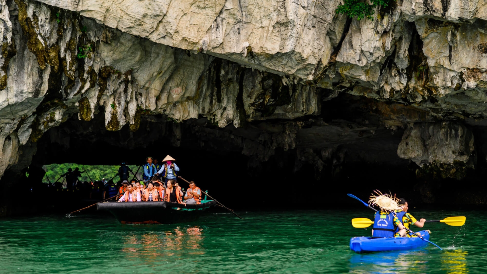 Sitting on the bamboo boat for sightseeing or kayaking to explore the Cave on your own