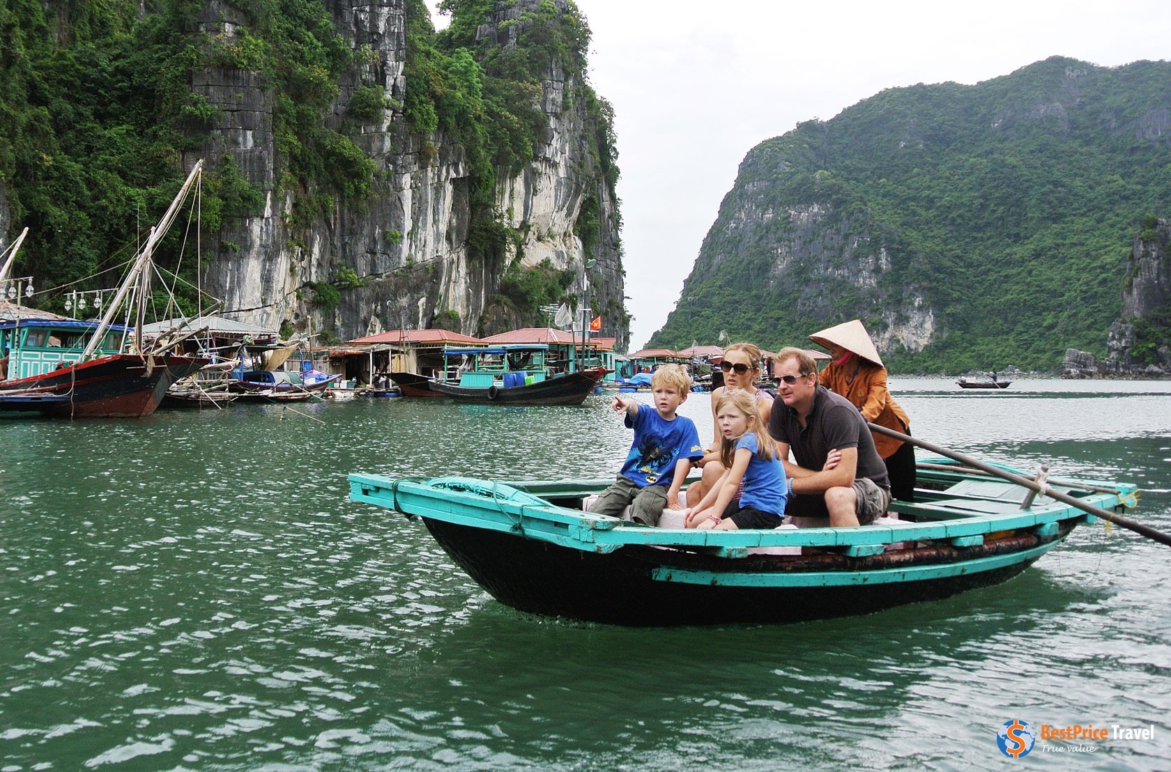 Family experiencing Halong Bay by rustic rowboat