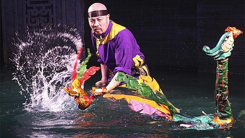 An artist is performing at Golden Dragon Water Puppet Theater