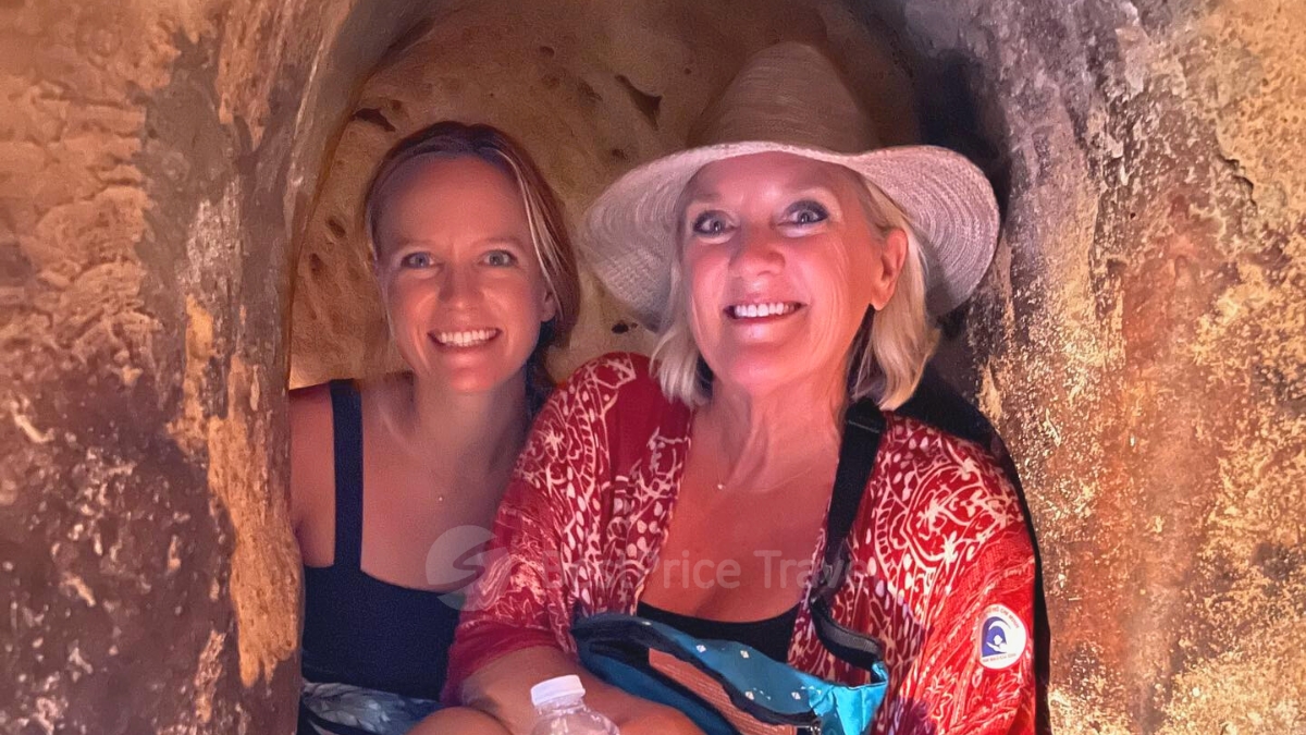 Two girls are exploring the underground of Cu Chi Tunnels