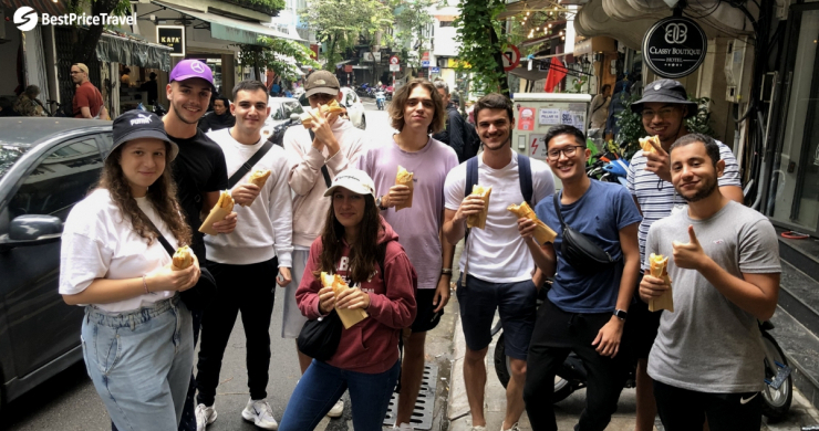 A Group Of Young Travelers Enjoy Vietnamese Bread Banh Mi